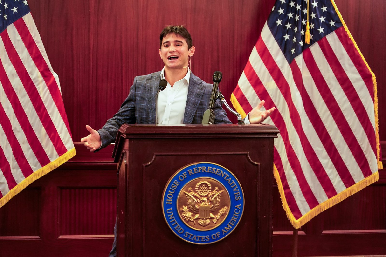 Sam Salz speaking at the U.S. House of Representatives, arms outstretched.