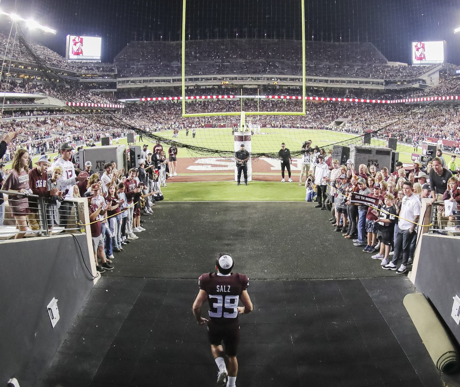 Sam Salz running out of the tunnel onto Kyle Field as fans cheer him on.